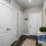 a white room with a mirror and a plant in it